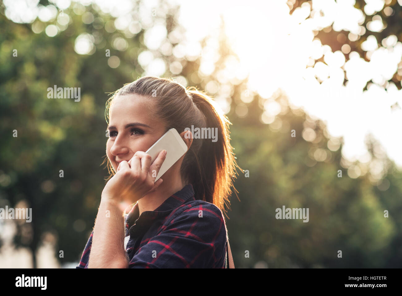 Attraktive junge Frau auf ihrem Handy außerhalb sprechen Stockfoto
