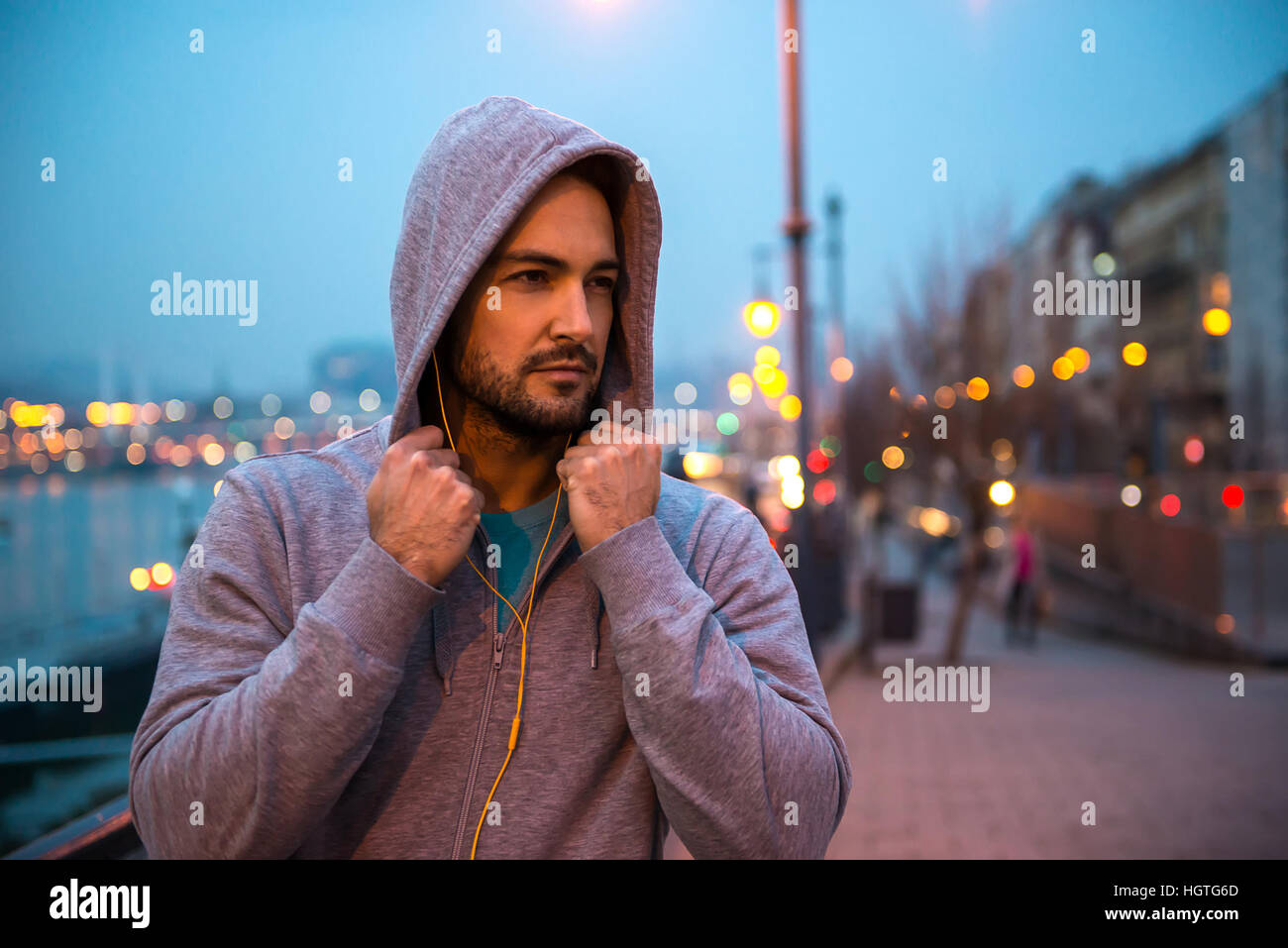 Porträt eines schönen jungen Sportlers stehen auf der Straße in die Lichter der Stadt bei Nacht Stockfoto