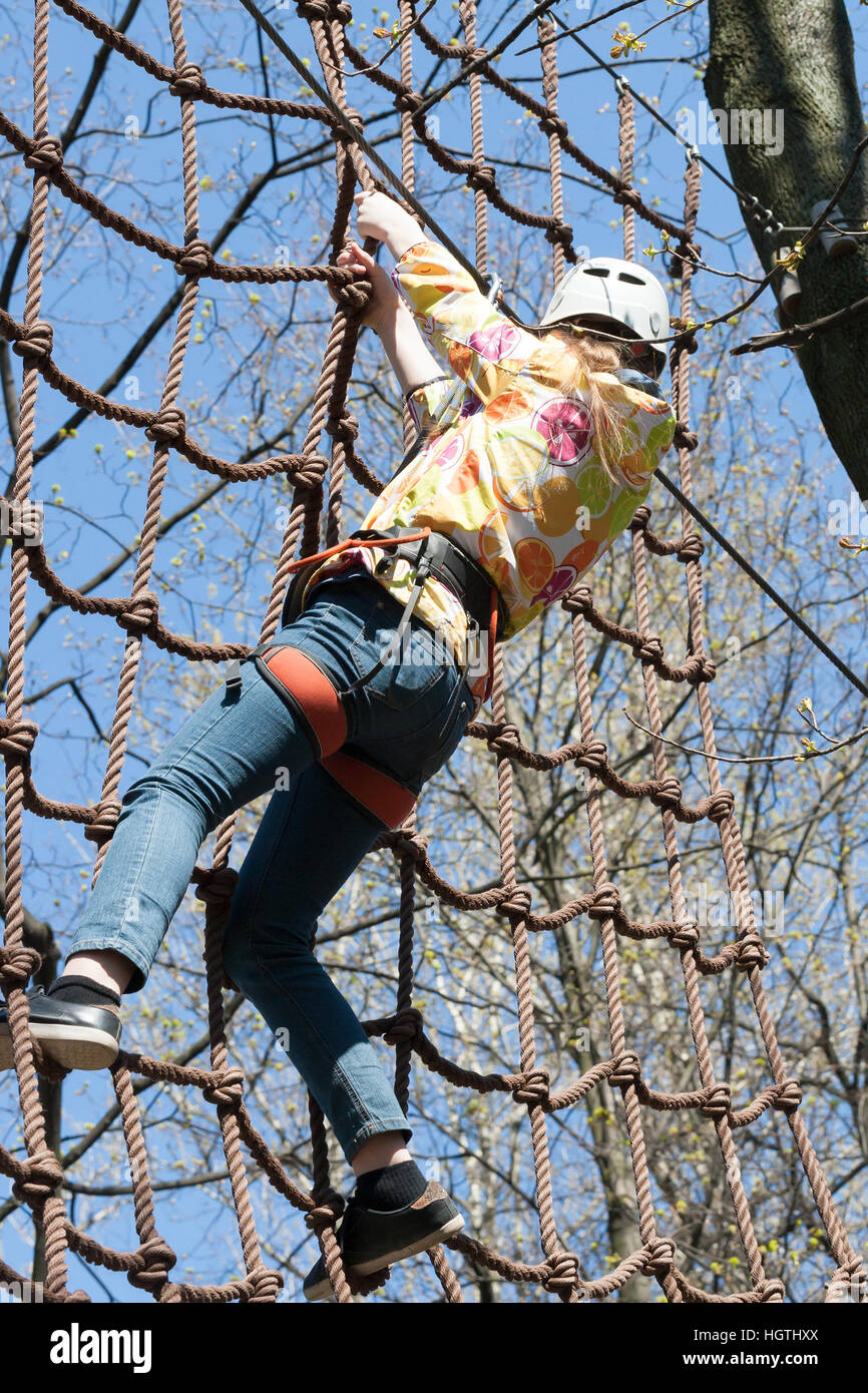 Das Mädchen klettert Hindernisse der Seilpark in klaren Sommertag Stockfoto