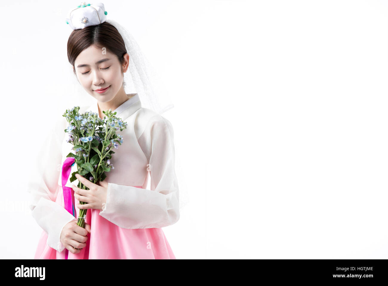Junge lächelnde Braut im koreanischen Tracht, schloß die Augen Stockfoto