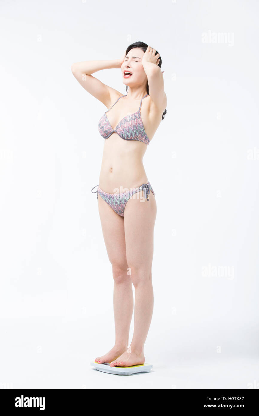 Seitenansicht des stressigen Mädchen im Bikini stehen auf einer Skala Stockfoto