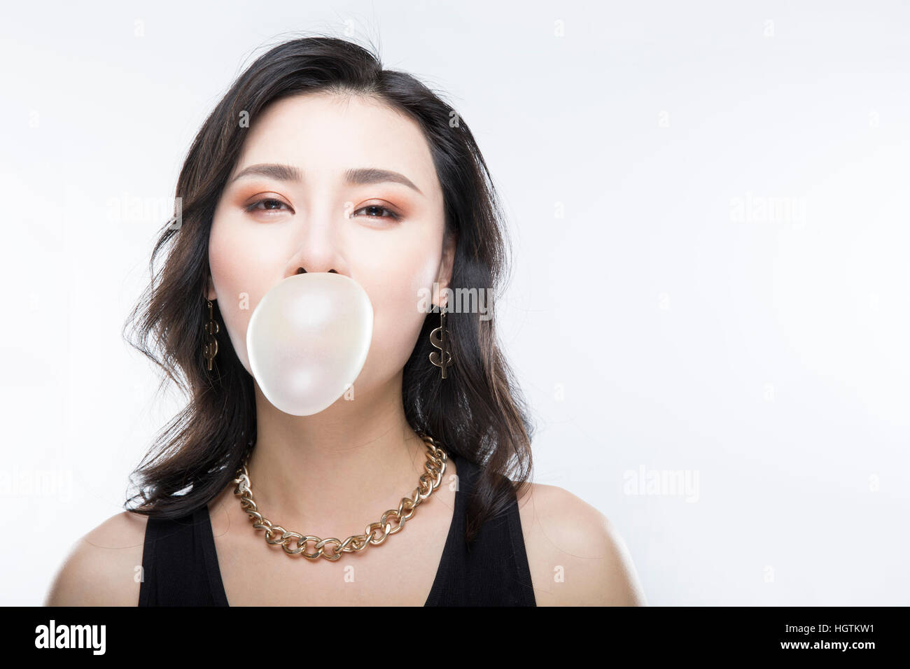 Porträt der jungen Frau im Hip-Hop-Stil weht Kaugummi Stockfoto