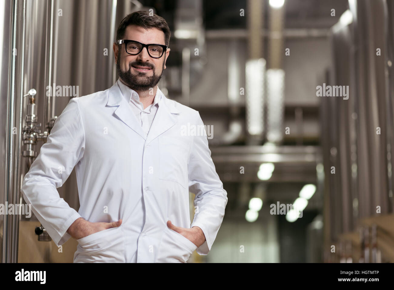 Lächelnder Mann posiert mit Brauen Mechanismen Stockfoto