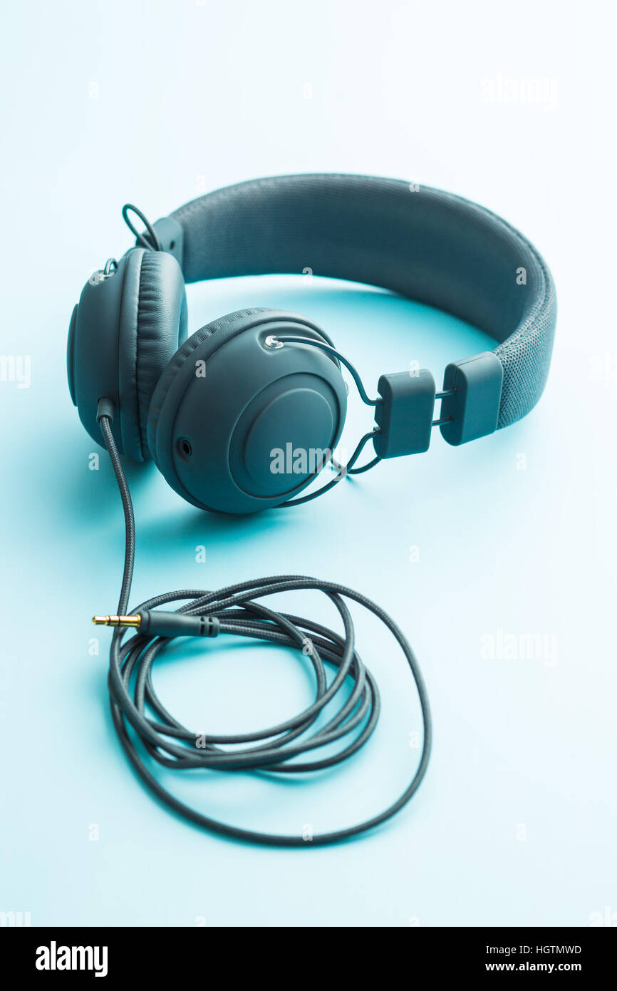 Graue Vintage Kopfhörer auf blauem Hintergrund. Stockfoto