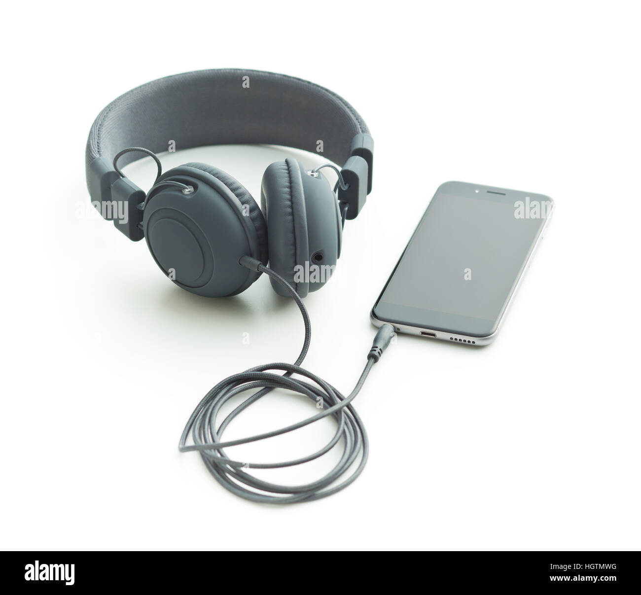 Graue Vintage Kopfhörer und Handy isoliert auf weißem Hintergrund. Stockfoto