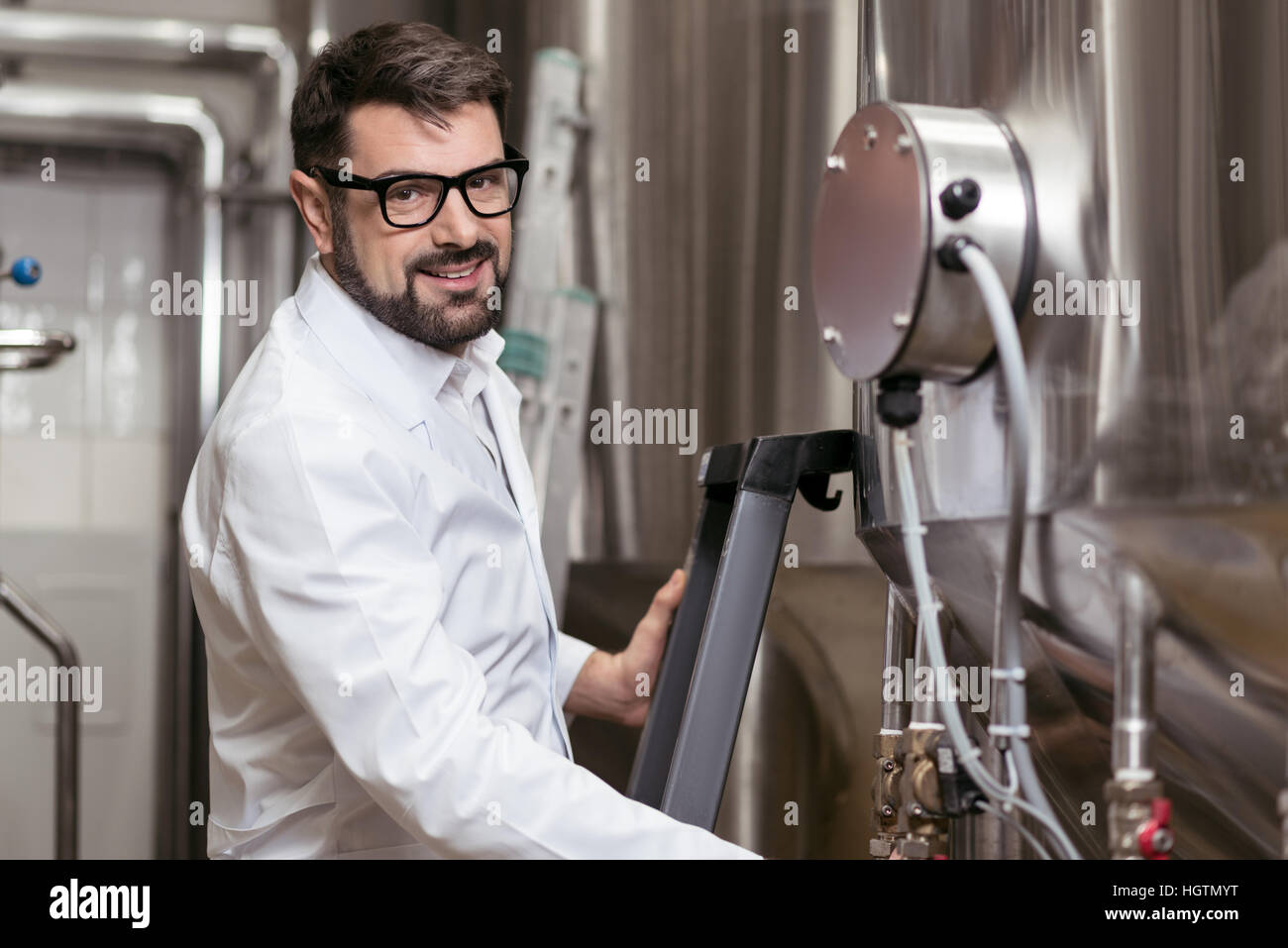Fröhliche Mann posiert mit Brauen Maschine Stockfoto