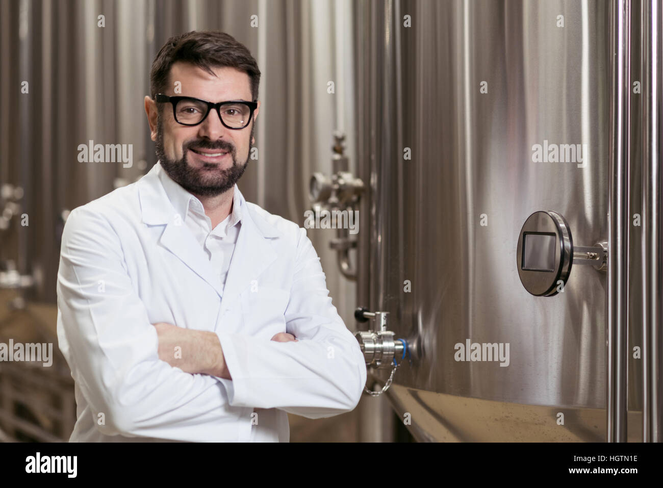 Glücklicher Mann posiert auf Brauen Fabrik Stockfoto