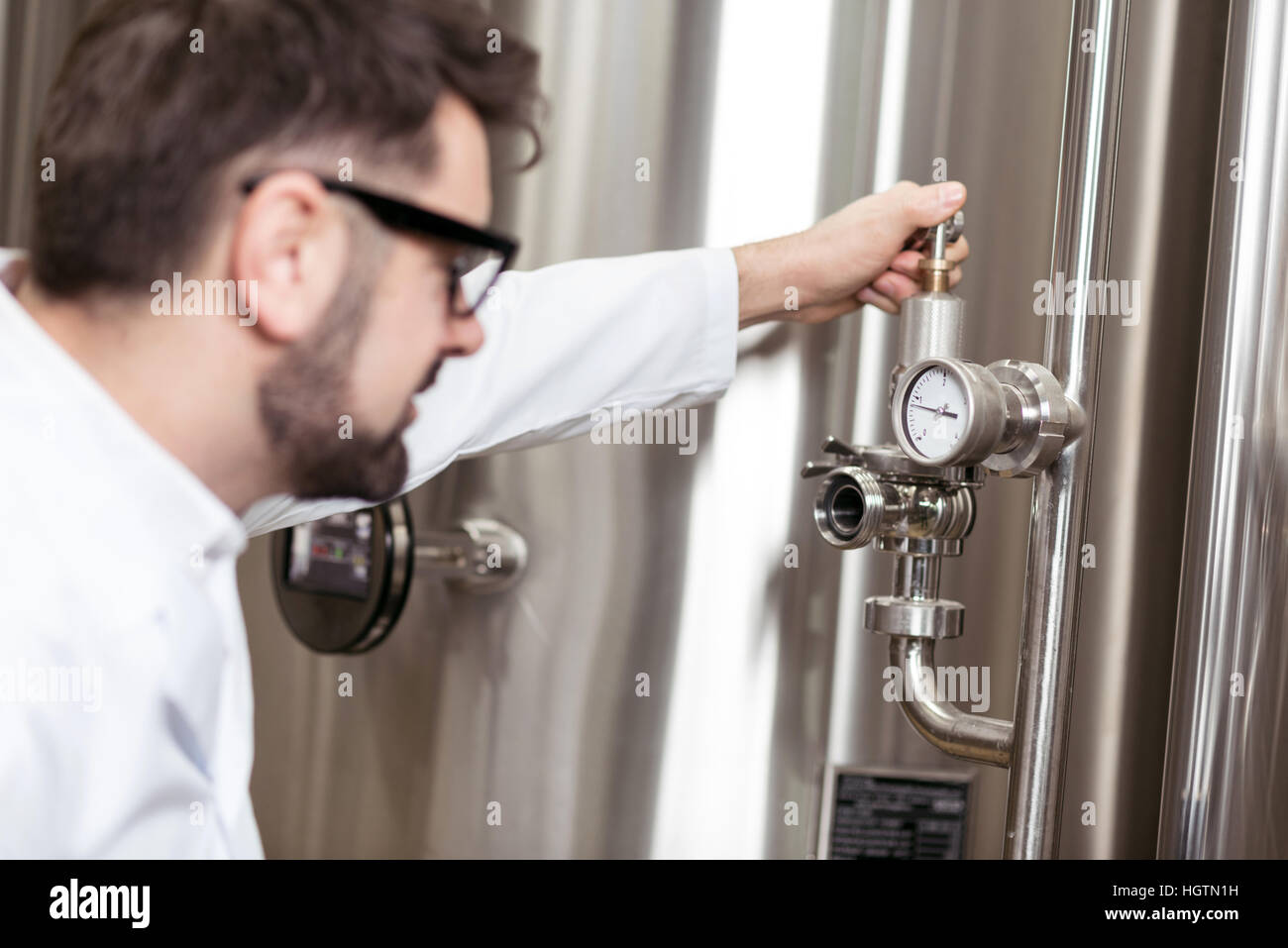 Glücklicher Mann mit Mechanismus auf Brauen Fabrik Stockfoto