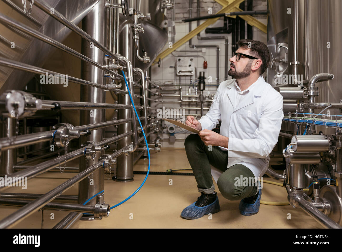 Mann sitzt am Bierfabrik konzentriert Stockfoto