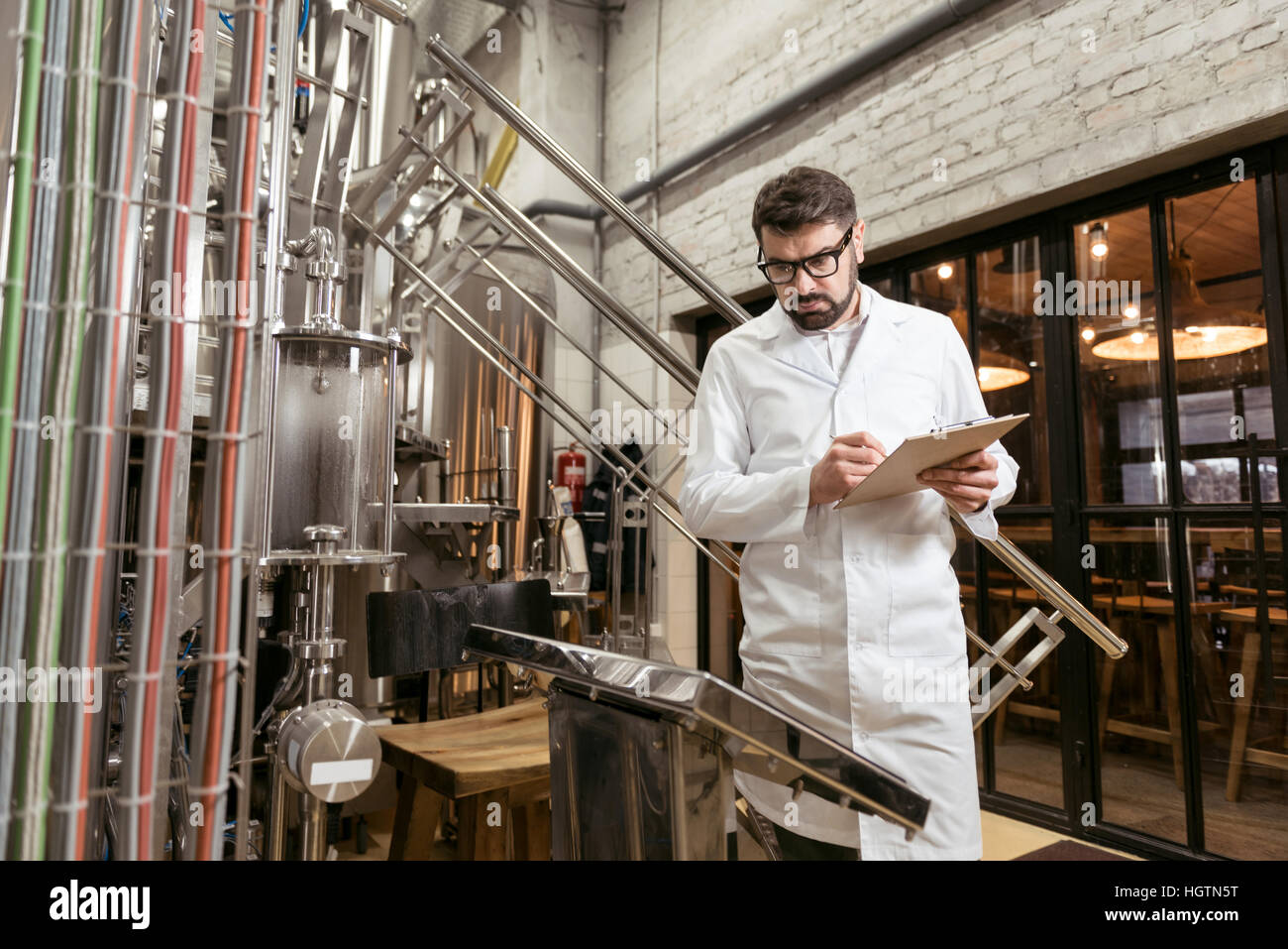 Ernster Mann Kenntnis nehmend von Ergebniswerten Bierfabrik Stockfoto