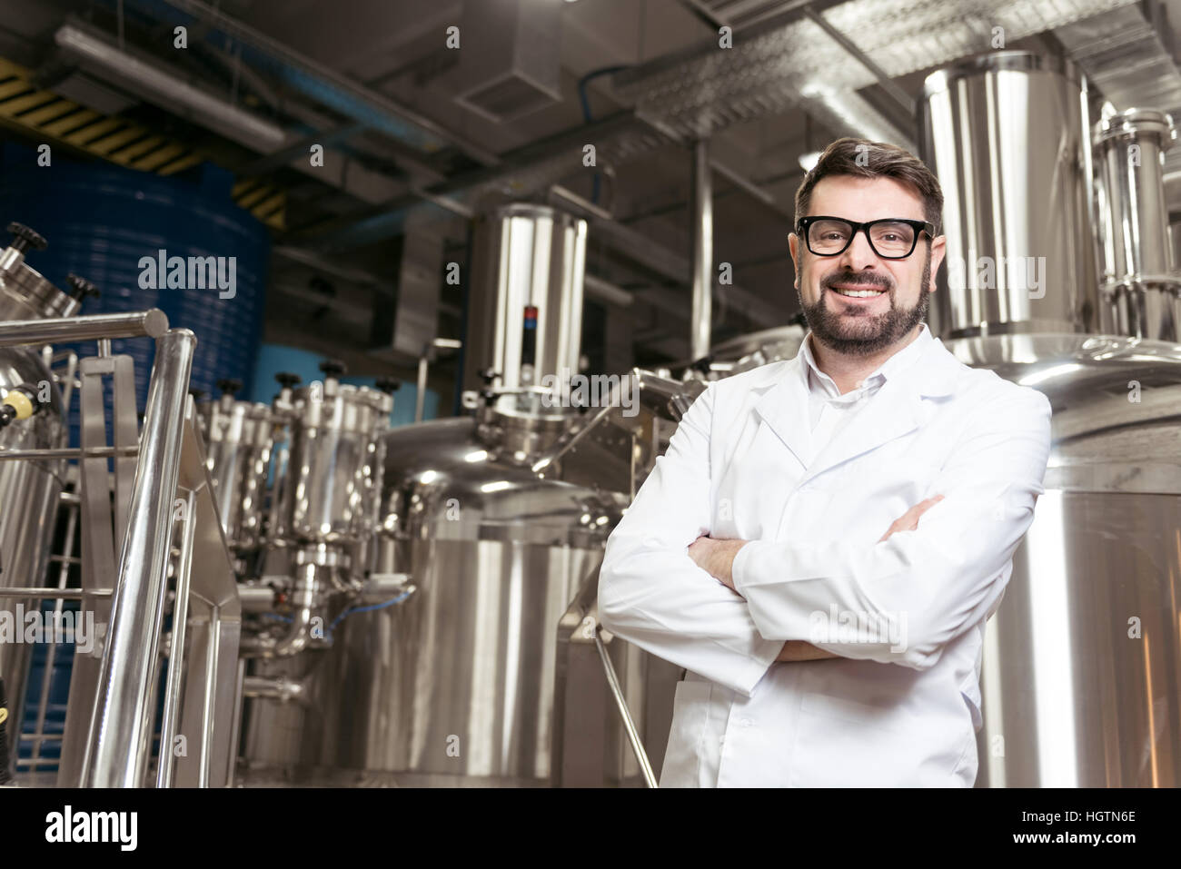 Lächelnder Mann posiert mit Brauen Mechanismen Stockfoto
