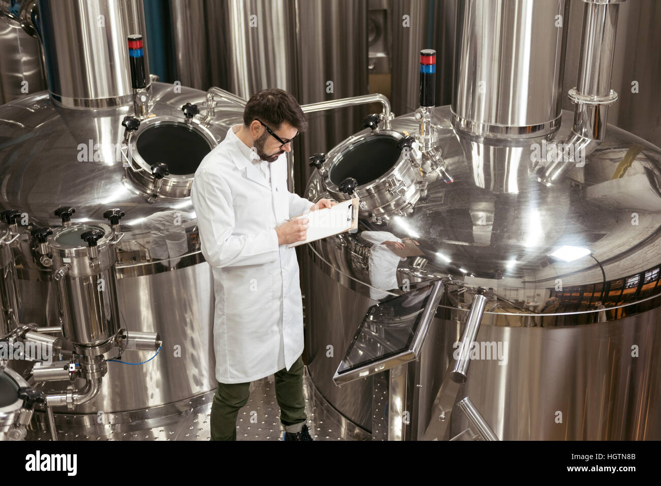 Gut aussehender Mann Kontrollmechanismen bei Bierfabrik Stockfoto