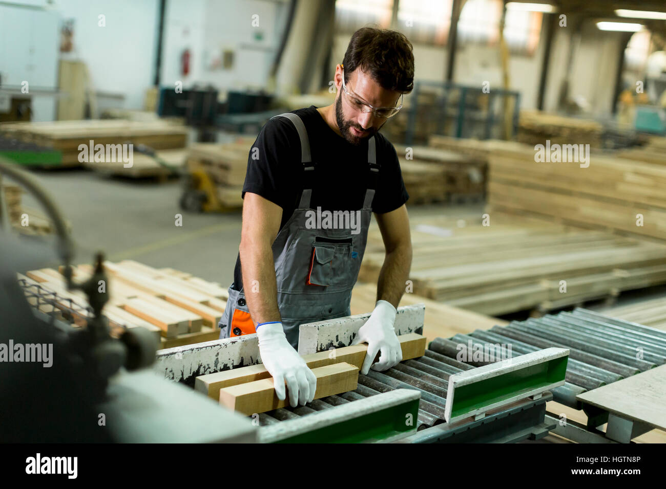 Hübscher junger Mann arbeitet in der Möbelfabrik Stockfoto