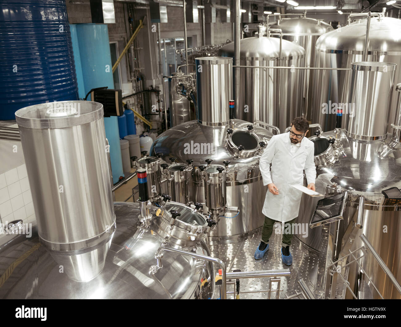 Verantwortlichen Mann stehend in Maschinen bei Bierfabrik Stockfoto