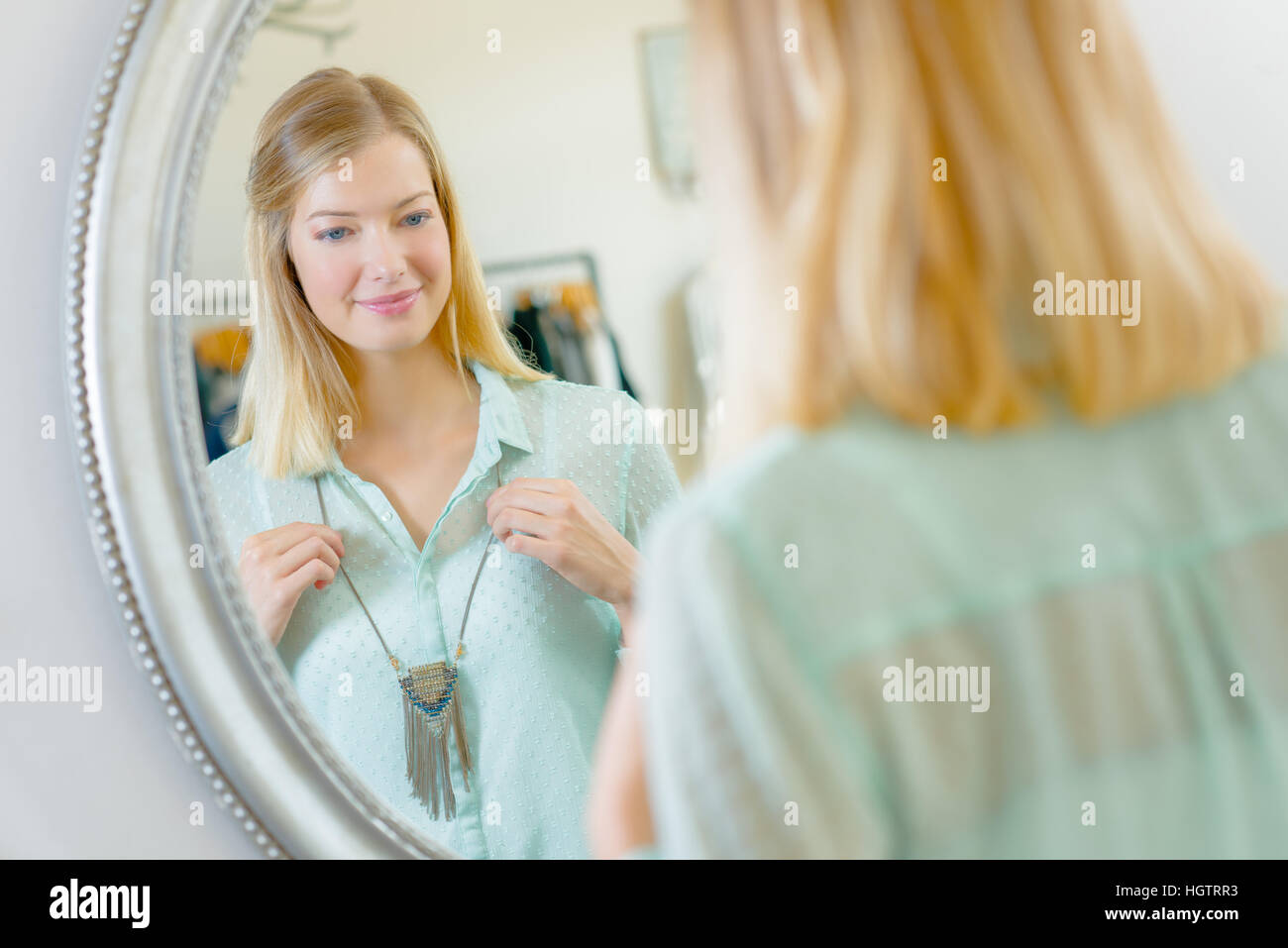 Lady Halskette vor Spiegel anprobieren Stockfoto