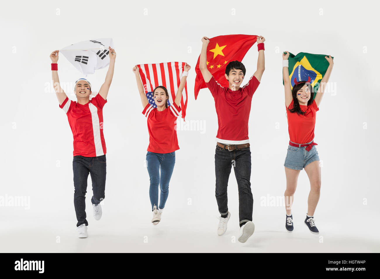 Junge lächelnde Cheerleader laufen mit Nationalflaggen Stockfoto
