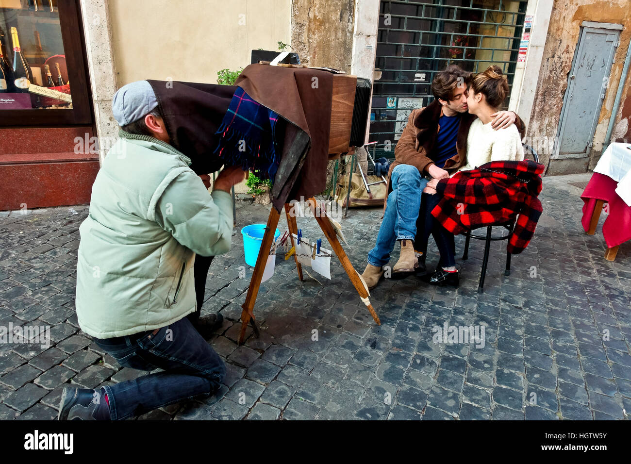 Junge verlobt Paar umarmen und küssen während posiert für ein romantisches Foto in einer Straße in Rom, Italien, Europa, EU. Valentinstag. Touristen. Stockfoto