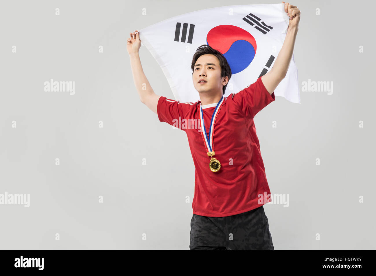 Männliche junge koreanische Sport Player mit Goldmedaille posiert mit koreanische Flagge Stockfoto