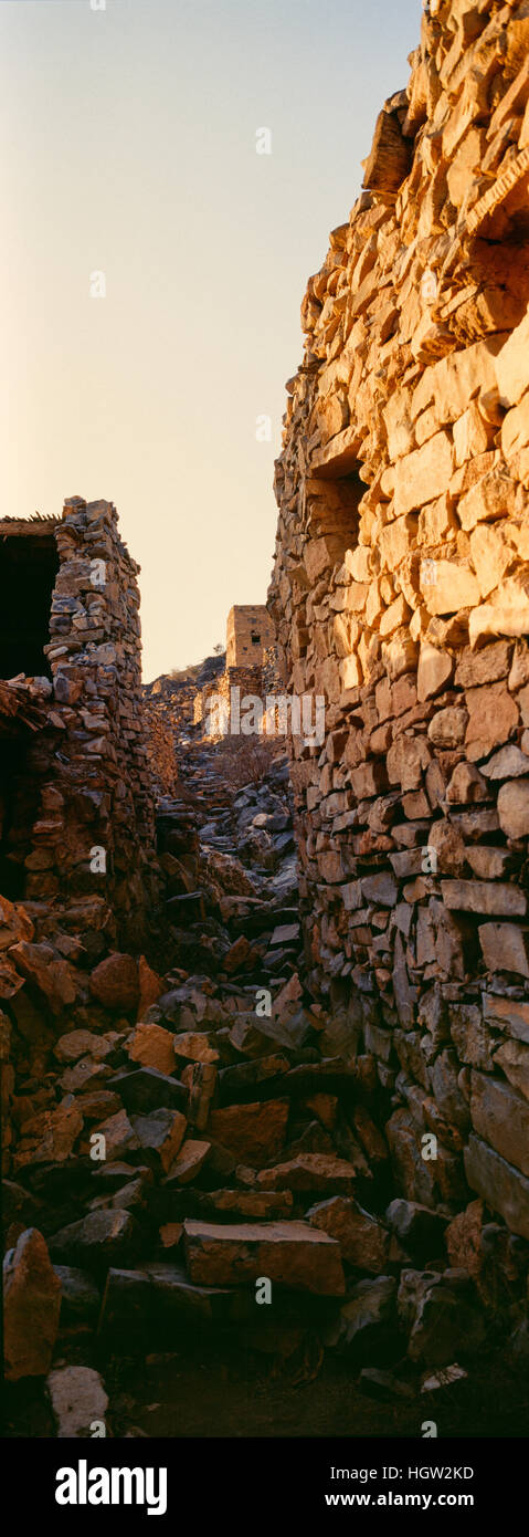 Alte handgemachte Steinbauten, Geschäfte und Häuser säumen eine Straße in ein verlassenes Dorf. Stockfoto