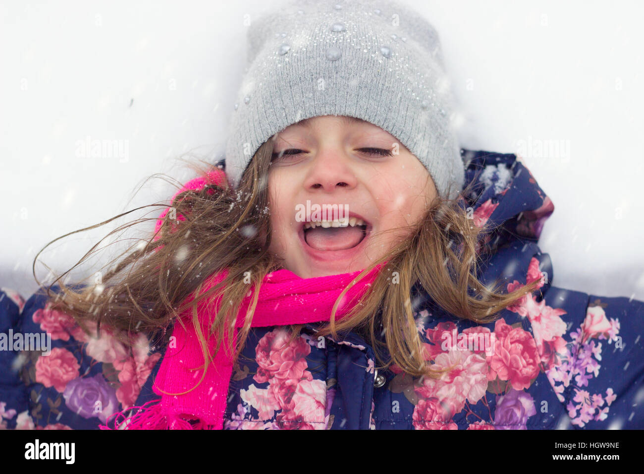 Kleines Mädchen genießen den Schnee Stockfoto