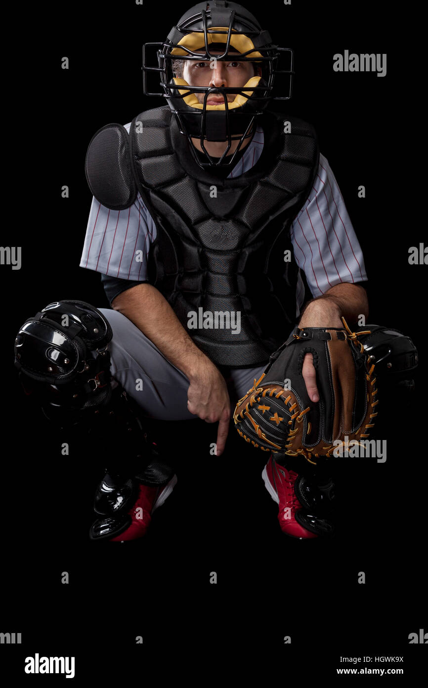 Baseball-Spieler, Catcher fordern einen schnellen Ball auf einem schwarzen Hintergrund. Studioaufnahme. Stockfoto