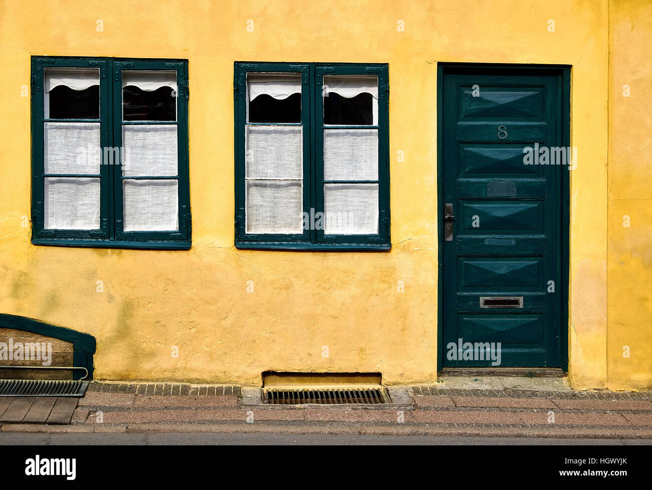 Die Fassade eines alten Stadthauses in Helsingør Dänemark mit gelb verputzten Wänden und grün bemalte Fenster und Tür Stockfoto