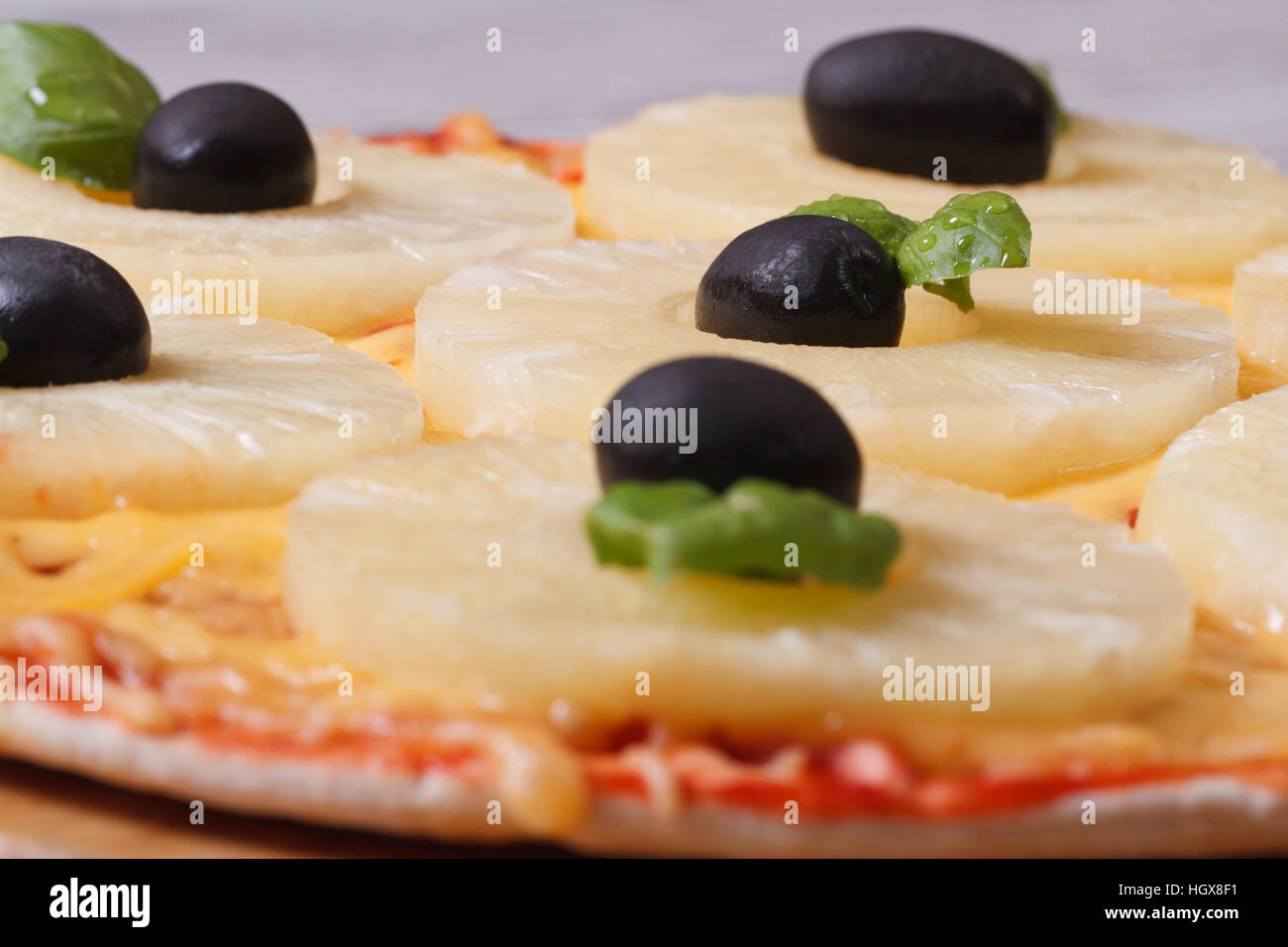 Pizza mit Ananas und schwarzen Oliven auf den Tisch. Makro. horizontale Stockfoto