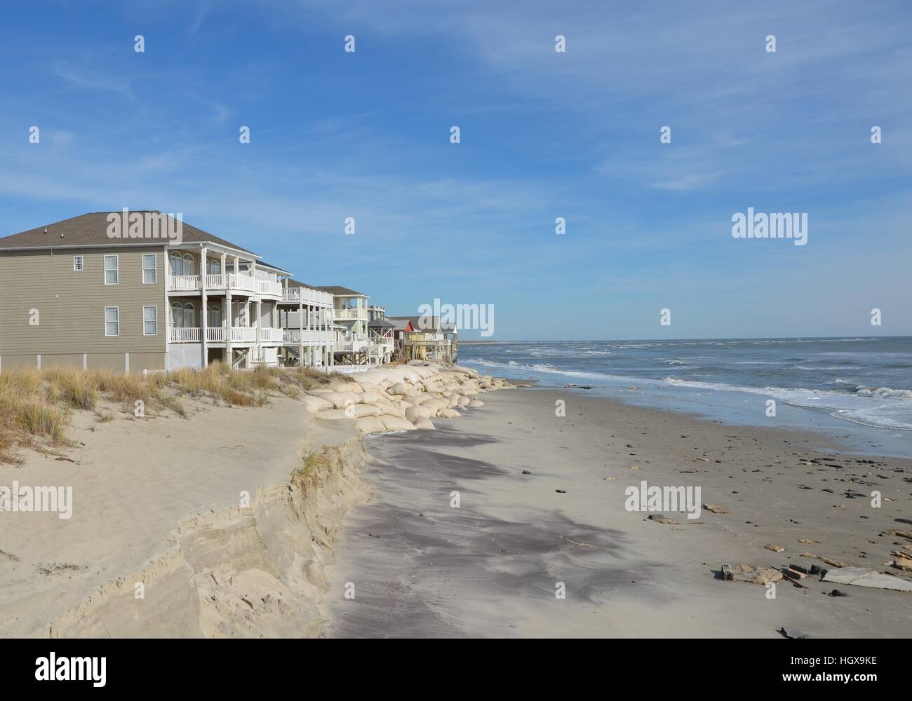 Häuser entlang der Küste durch Sandsäcke geschützt Stockfoto