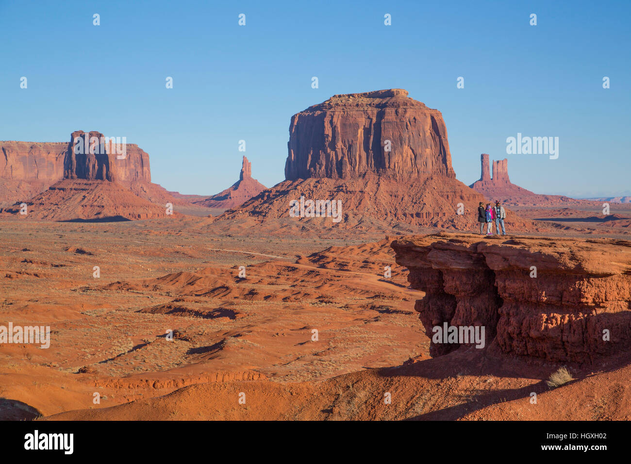 Touristen, John Ford Point (im Vordergrund), Merrick Butte (Hintergrund), Monument Valley Navajo Tribal Park, Utah, USA Stockfoto