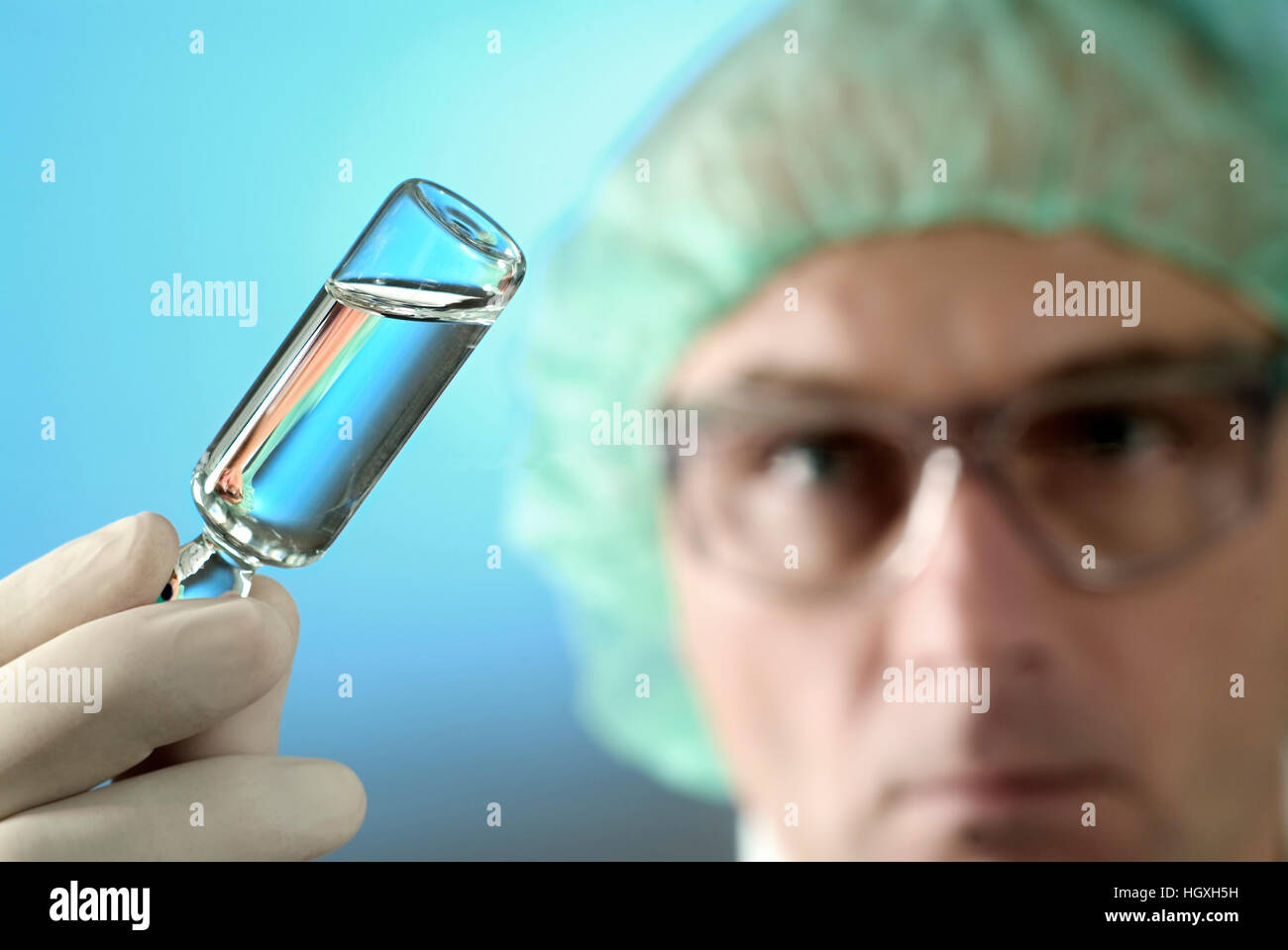 Wissenschaftler hält eine kleine Flasche mit klarer Flüssigkeit zu überprüfen. Stockfoto