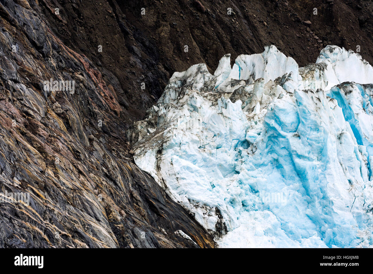 Die Lippe eines Gletschers Schleifen vor einer steilen Klippe in einem Fjord. Stockfoto