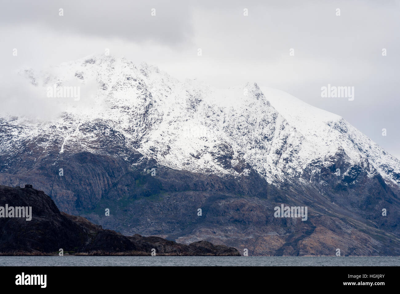 Die Schneegrenze einer Bergkette über eine arktische Fjord. Stockfoto
