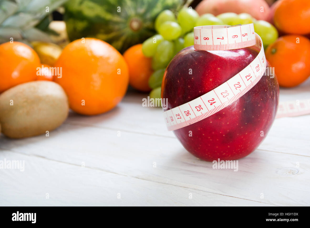 Apple und Maßband über fruchtigen Hintergrund Stockfoto
