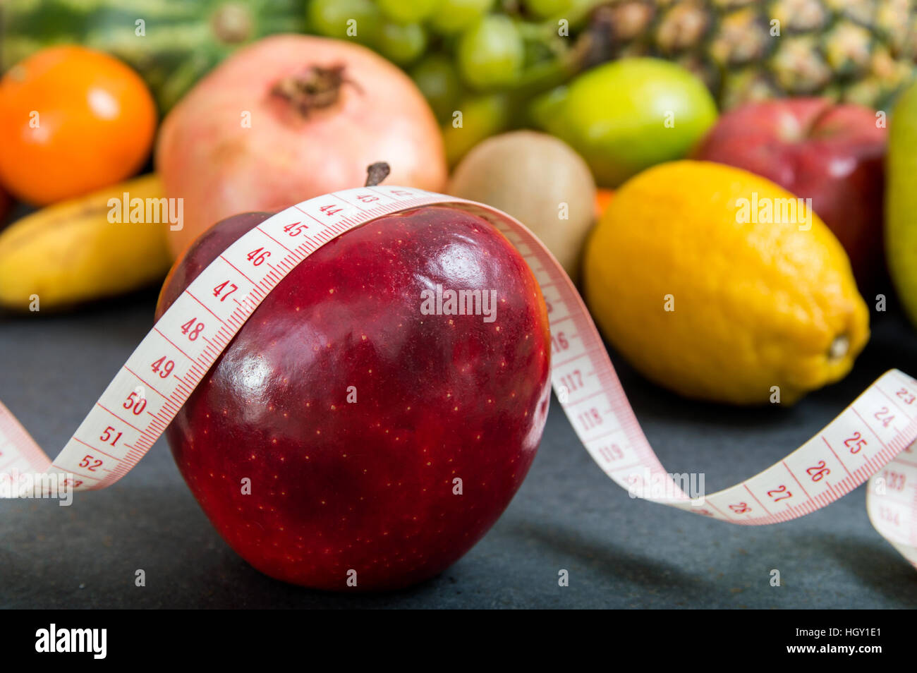Apple und Maßband über fruchtigen Hintergrund Stockfoto