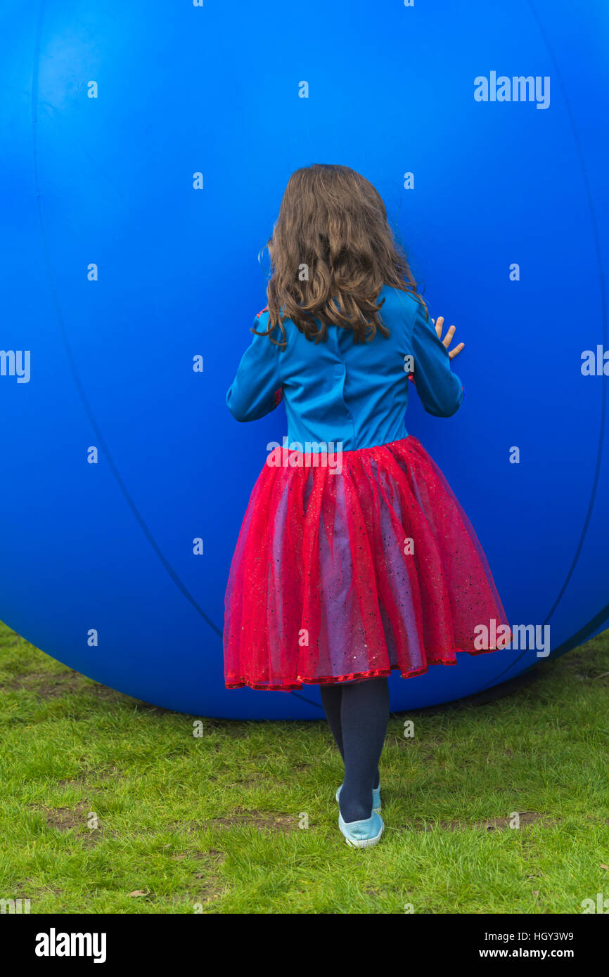 Mädchen fühlt die Schwingungen und hört sich die Musik der blaue Kugel Ball in Bournemouth Kunst durch die Sea Festival in Bournemouth im Oktober siehe Beschreibung Stockfoto