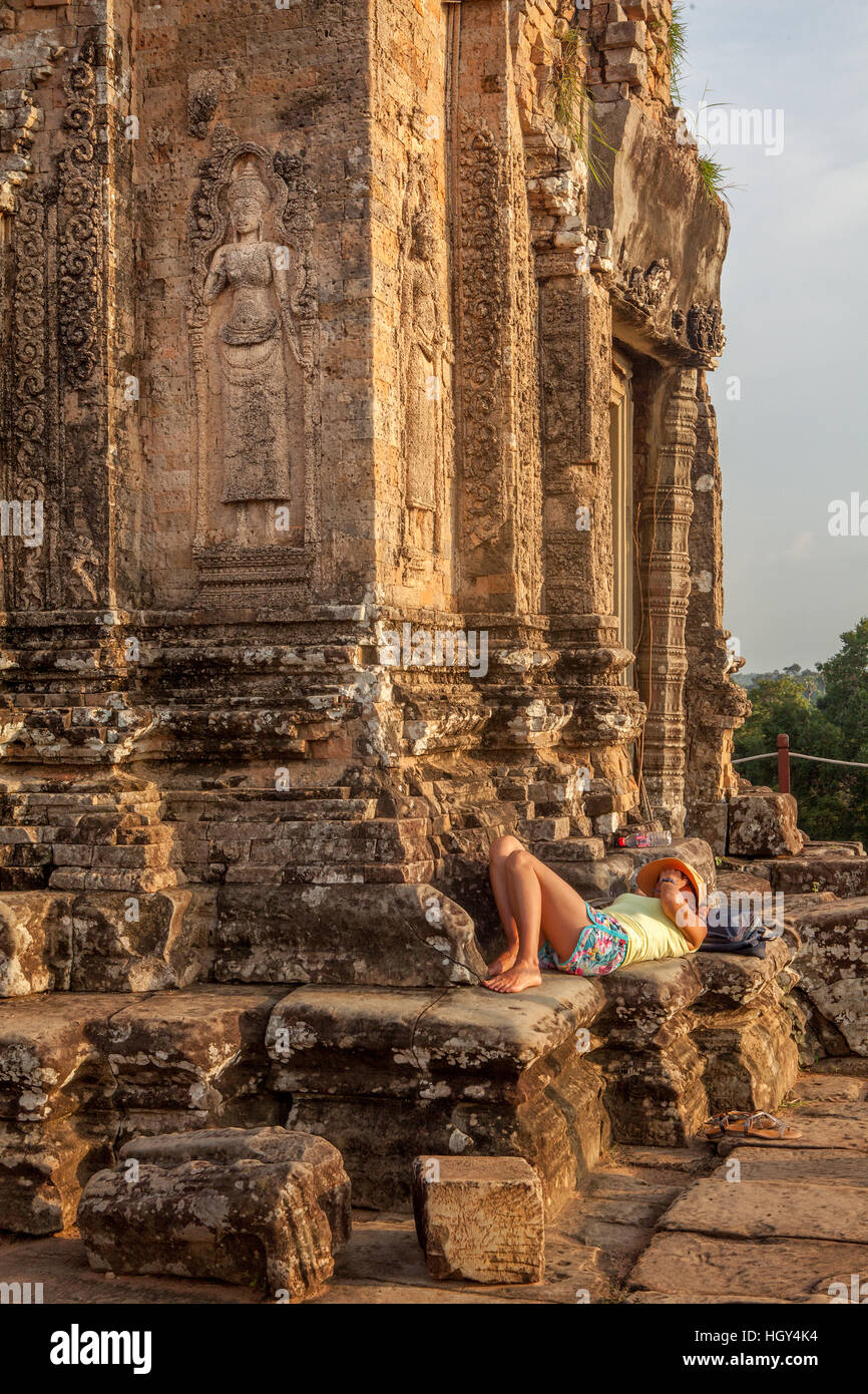 Müden Touristen ruht auf einem Tempel im späten Nachmittag, die untergehende Sonne am Pre Rup, Siem Reap, Angkor, Kambodscha. Stockfoto
