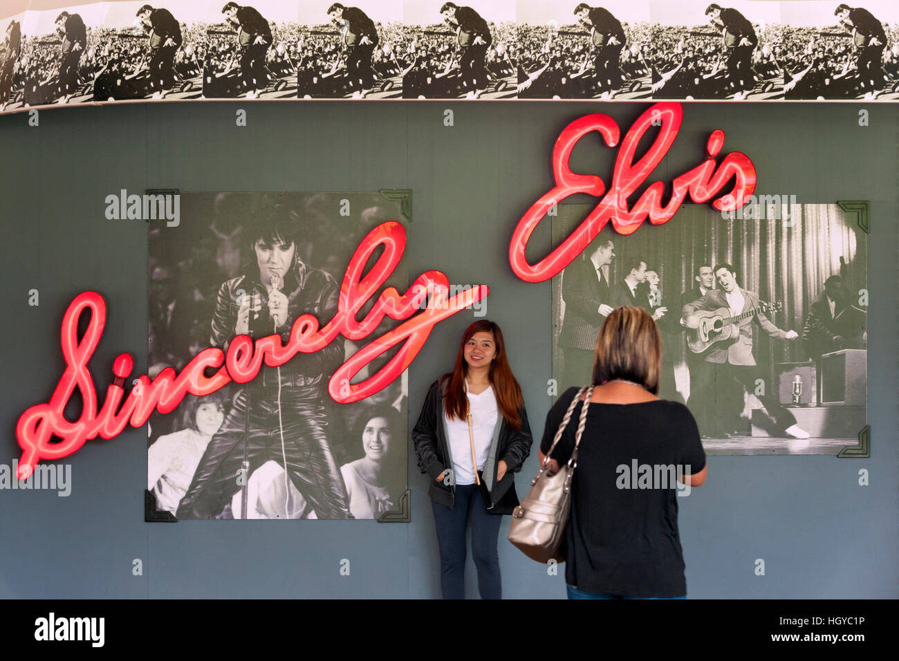 Frau posiert vor Elvis Leuchtreklame in Graceland, Memphis, Tennessee, USA Stockfoto