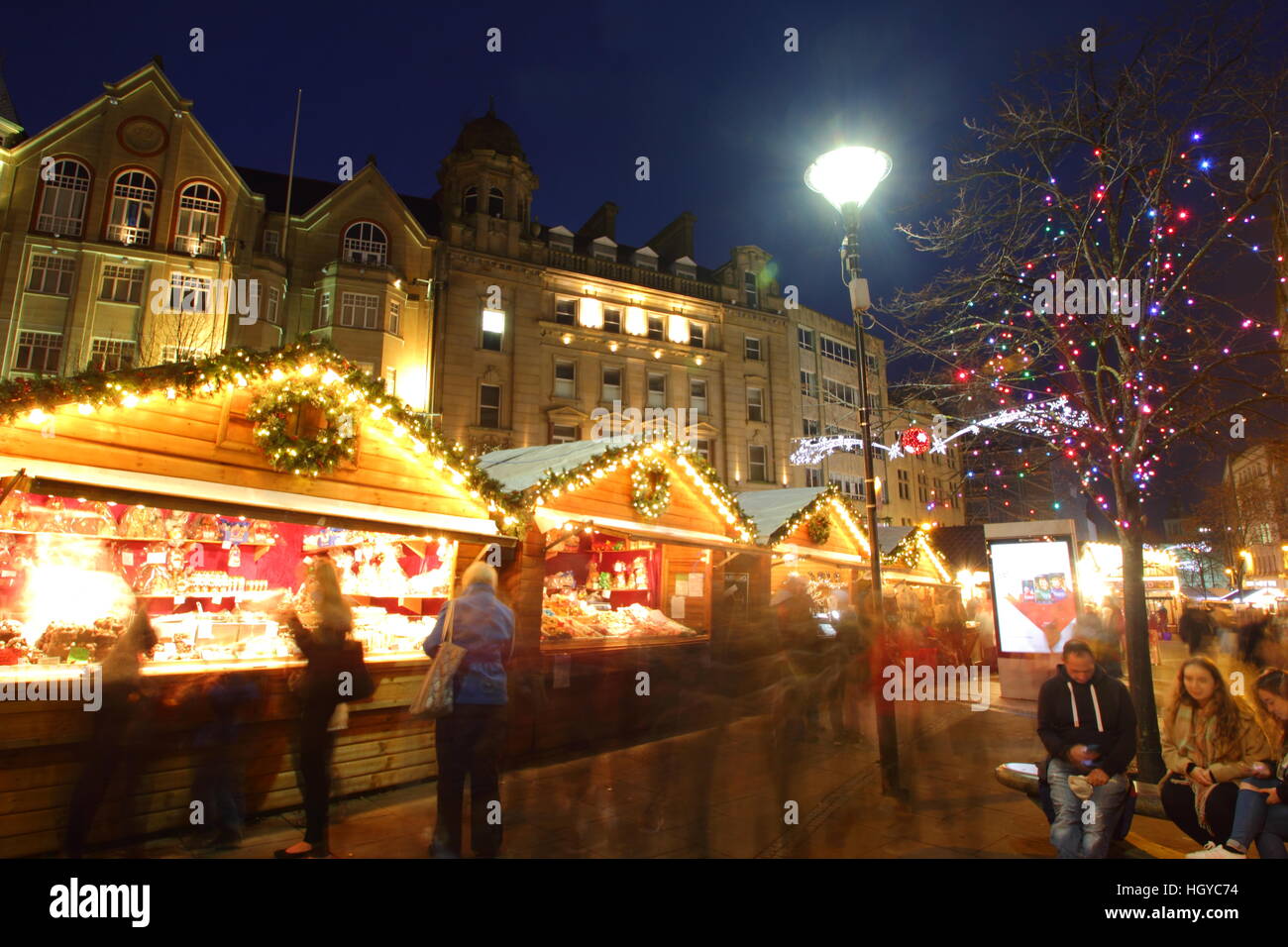 Festliche Shopper durchsuchen waren in niedlichen Holzhütten auf dem Weihnachtsmarkt am Fargate Sheffield Stadtzentrum Yorkshire, England Stockfoto