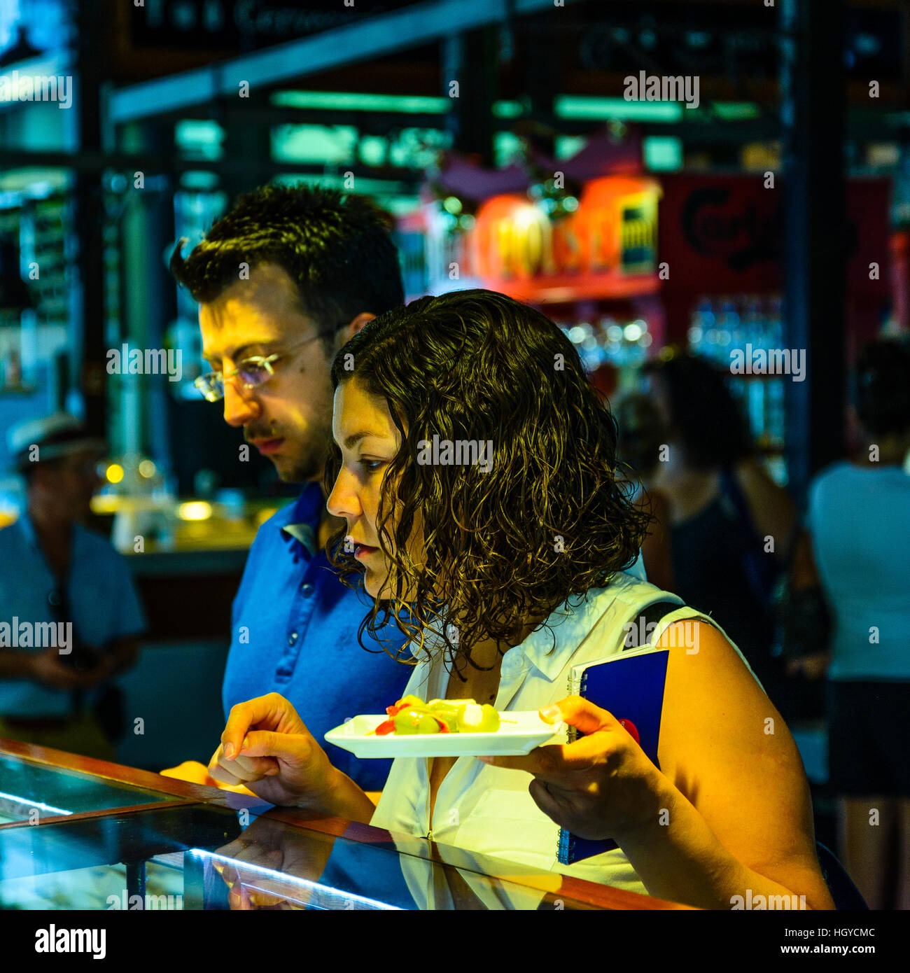 Junges Paar, die Auswahl der Speisen an einem Imbissstand in Mercado de San Miguel Madrid Spanien Stockfoto