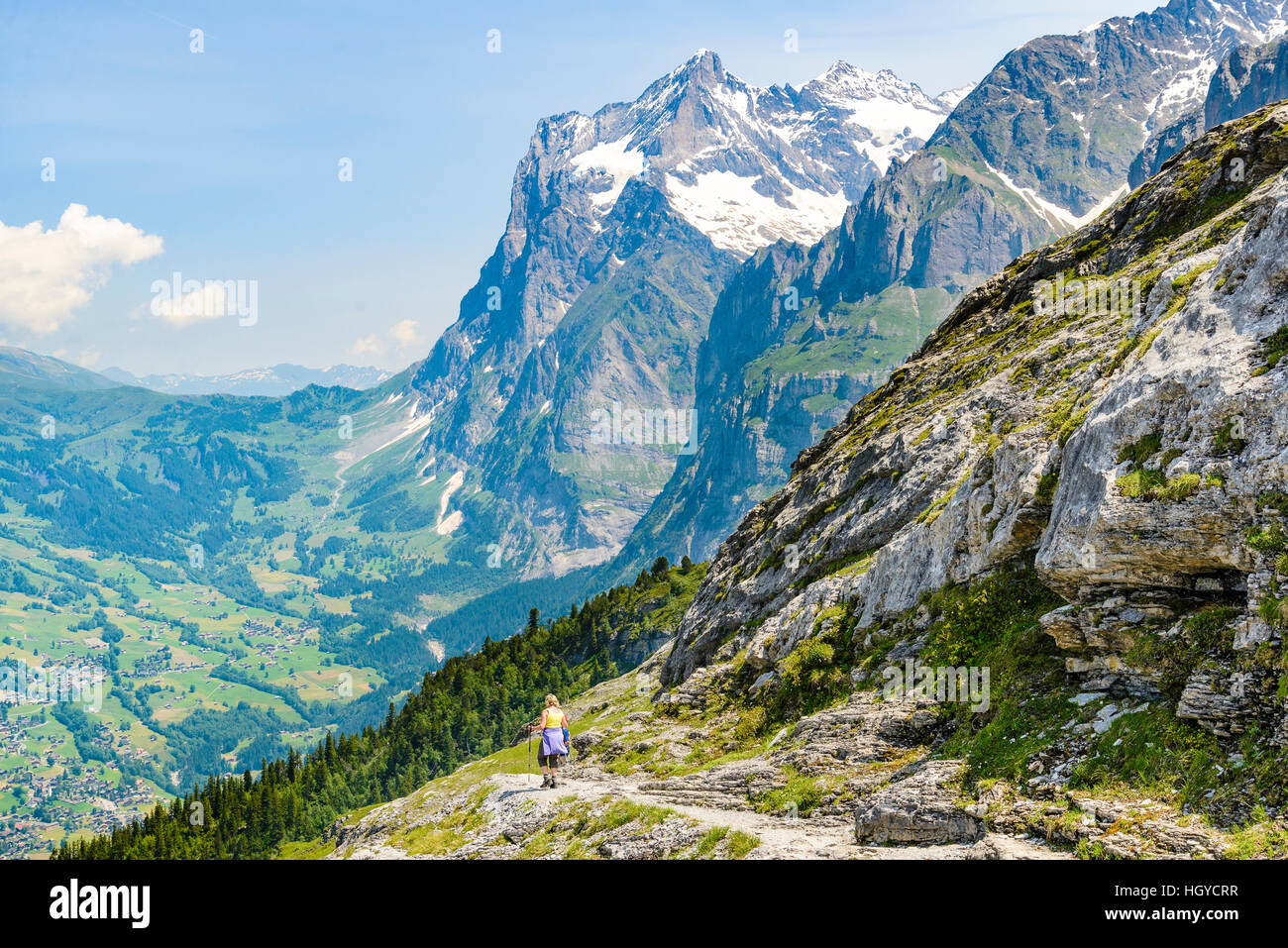 Wanderer auf den Eiger Trail Schweiz mit das Tal von Grindelwald und Wetterhorn Peak hinter Stockfoto