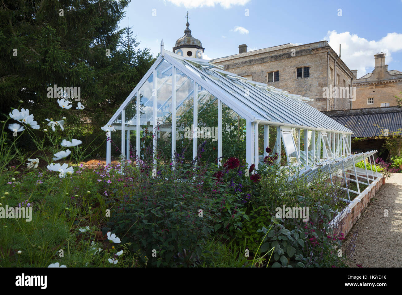 Baumschule Garten von Rousham House mit Gewächshaus und offene Kaltrahmen mit Stableblock und Haus hinter, Oxfordshire, England Stockfoto