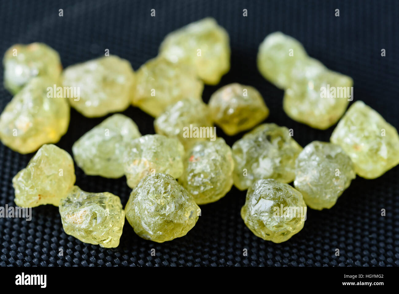 Sammlung von grünen ungeschnitten Mali Granat Edelsteine auf schwarzem Stoff. Stockfoto