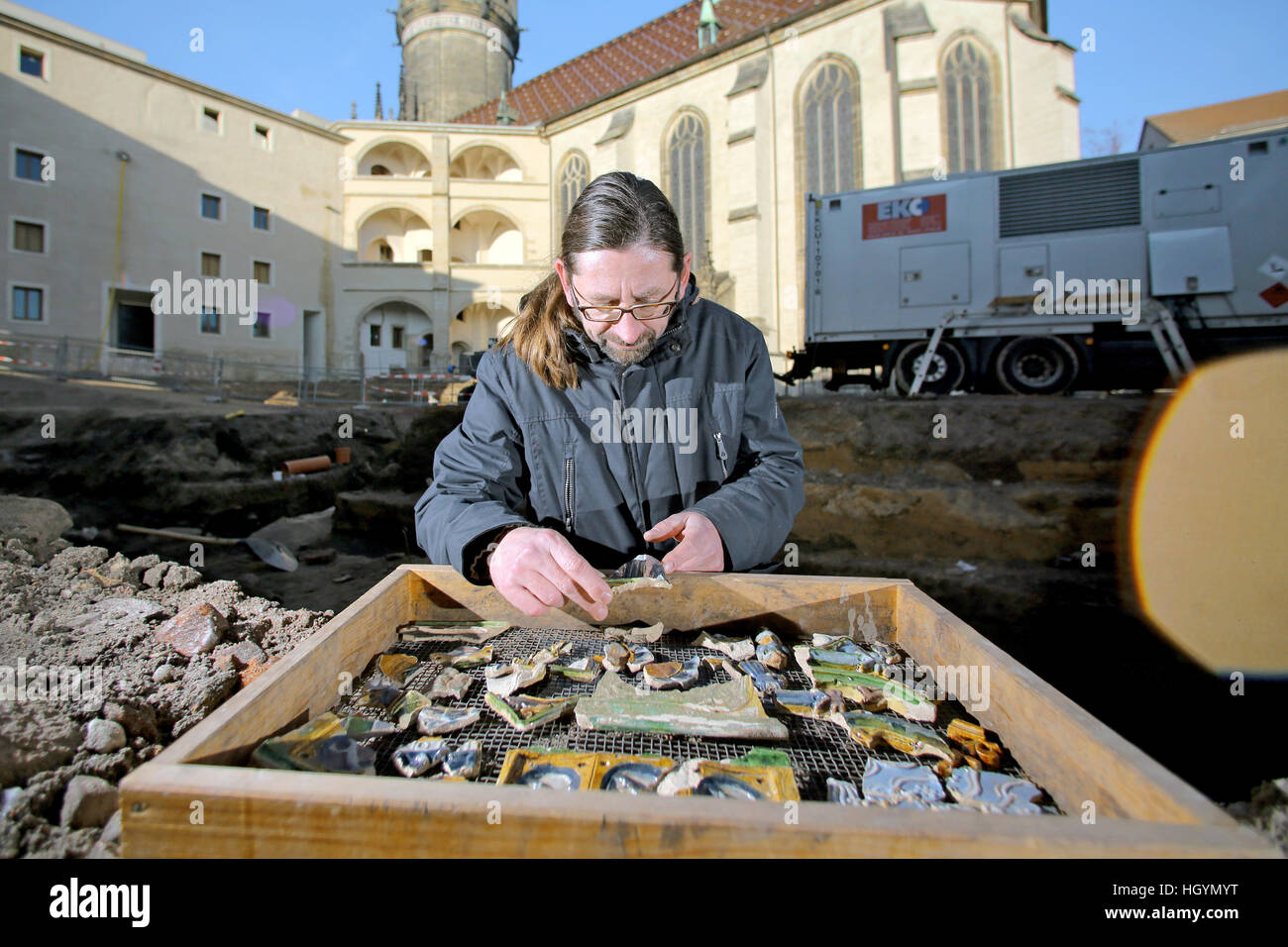 Wittenberg, Deutschland. 16. Dezember 2016. Archäologe Holger Rode sortiert die Überreste der Ofen Fliesen während einer archäologischen Ausgrabung auf dem Gelände des Schlosses in Wittenberg, Deutschland, 16. Dezember 2016. Archäologen fanden die Überreste von Tausenden von Schiffen und farbigen Ofen und Bodenfliesen aus der Zeit Luthers zu trinken. Friedrich der Weise (1463-1525) begann mit dem Bau der Burg um 1480. Luther wird geglaubt, um die gleiche Art von Ofen als Frederick besessen haben. Foto: Jan Woitas/Dpa-Zentralbild/ZB/Dpa/Alamy Live News Stockfoto