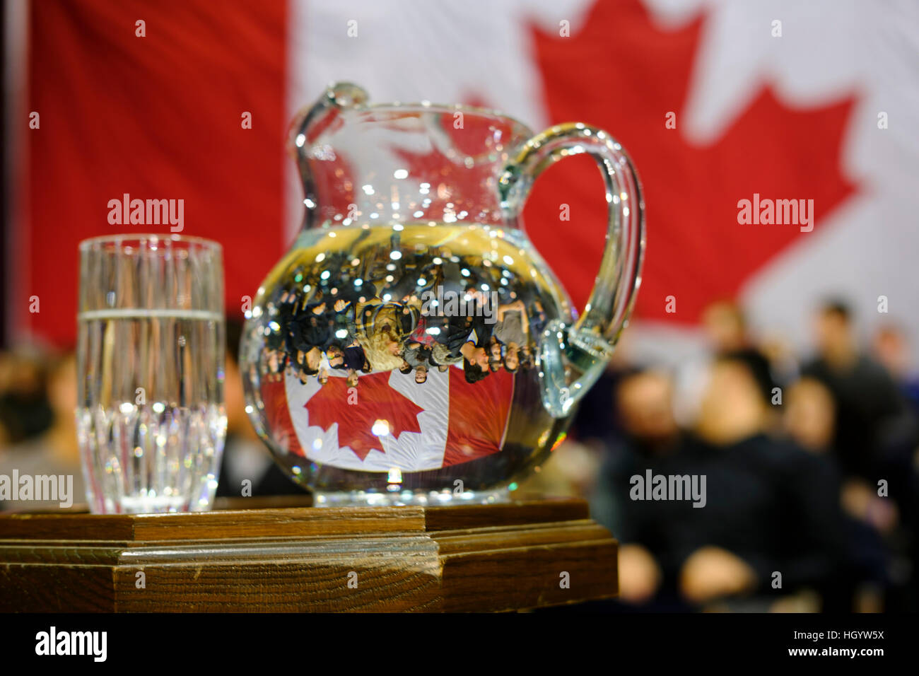Ein Wasserkrug spiegelt die kanadische Flagge und eine Gruppe von Bürgern in einer Bürgerversammlung in London, Ontario, Kanada. Stockfoto