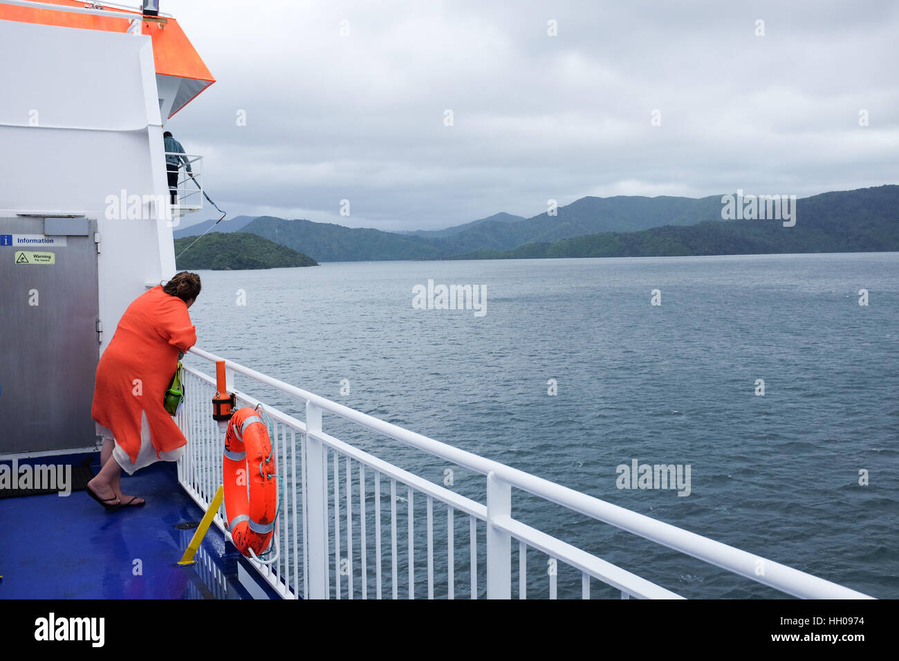 Eine Frau schaut aus der Kaiarahi Interislander Fähre in Neuseeland, wie es nach Picton von Wellington durch Queen Charlotte Sound segelt. Stockfoto