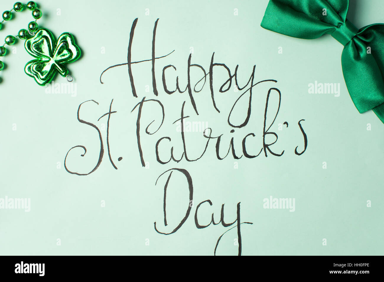 Happy St. Patrick-Tageskarte der Kalligraphie und grüne Zubehör Stockfoto