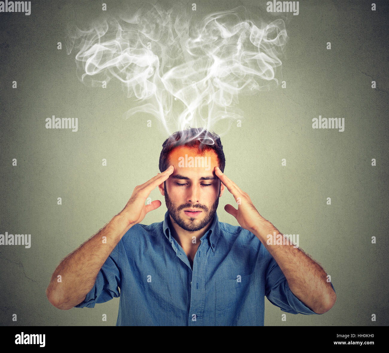 Mann denkt sehr intensiv mit Kopfschmerzen auf graue Wand Hintergrund isoliert Stockfoto