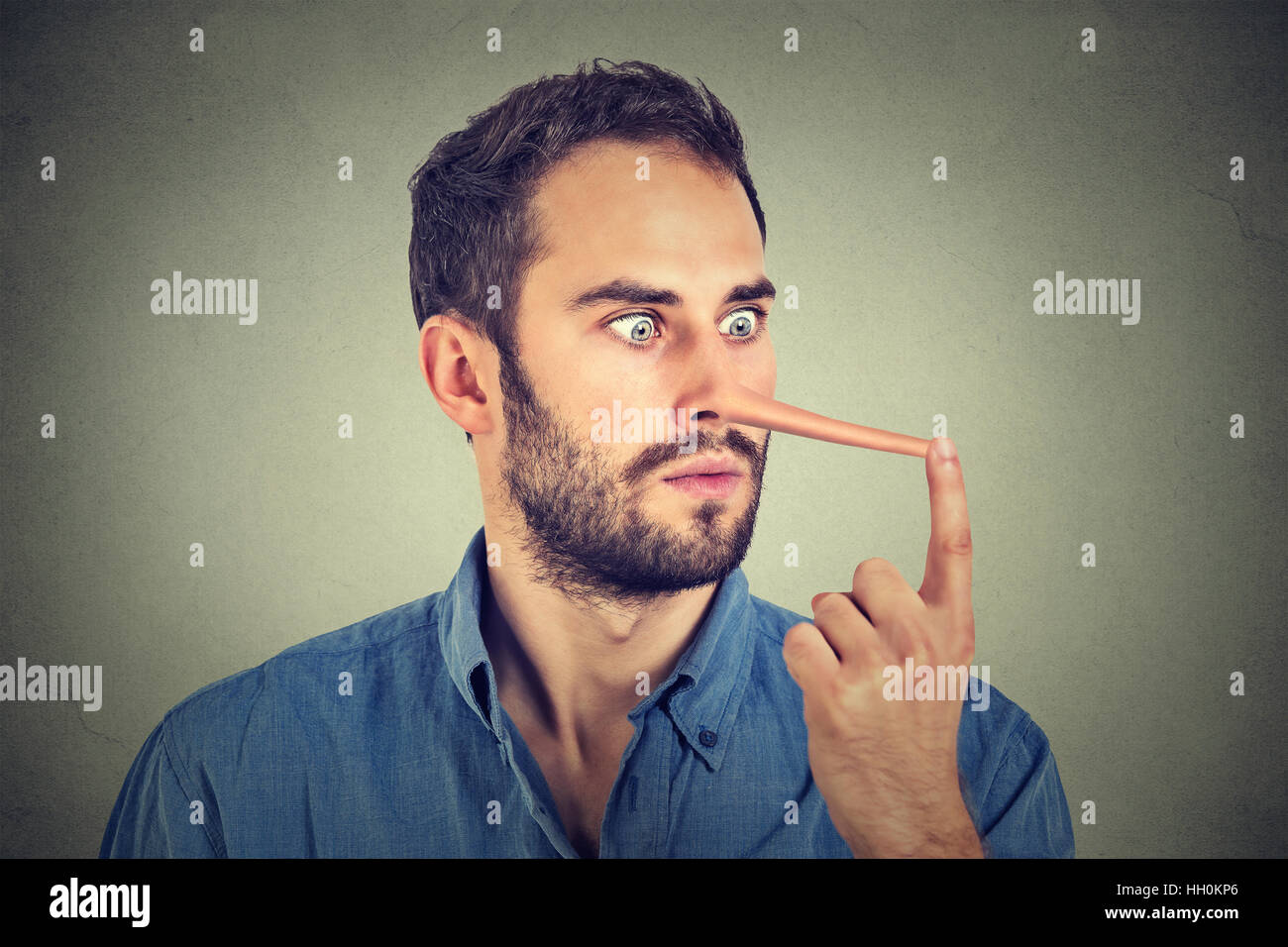Mann mit langer Nase auf graue Wand Hintergrund isoliert. Lügner-Konzept. Menschlichen Gesichtsausdruck, Emotionen, Gefühle. Stockfoto