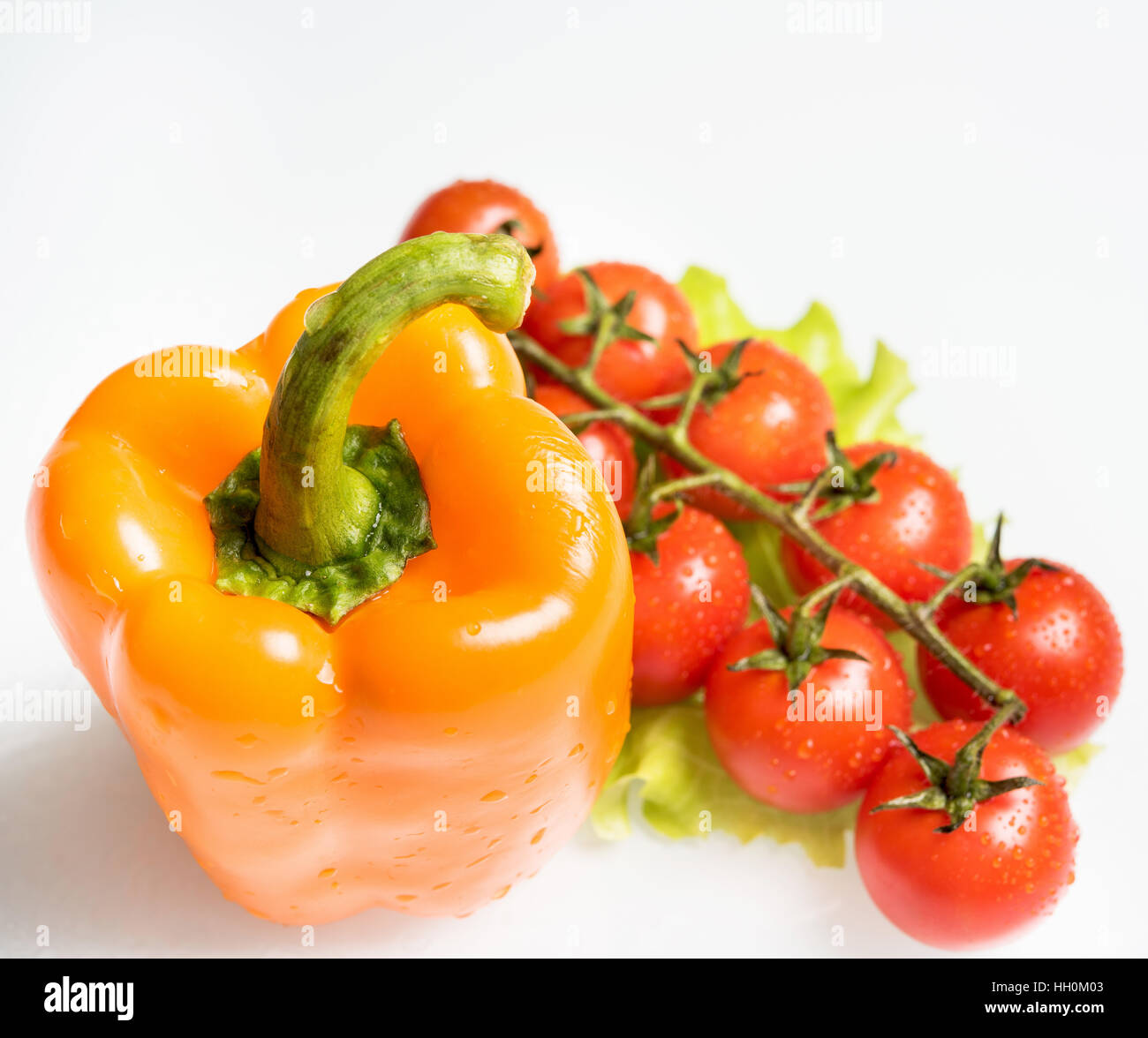 gelbe Paprika mit einem Zweig von Tomaten Stockfoto