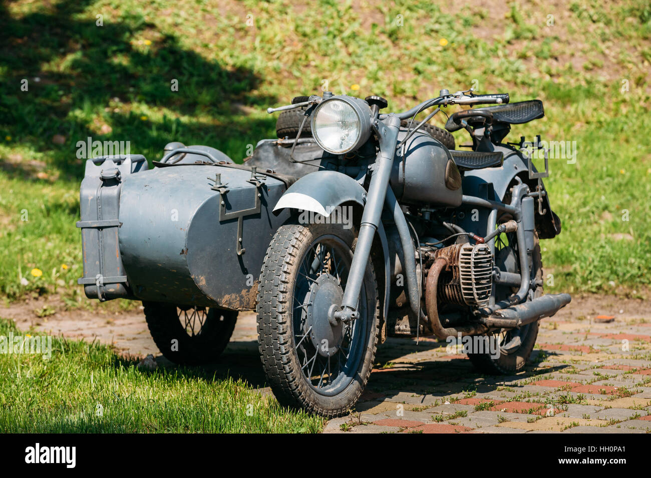 Die alte Rarität Dreirad, Dreirad-graue Motorrad mit Beiwagen der Wehrmacht 2. Weltkrieg Zeit stehend als Schauobjekt In sonnigen Sommerpark. Stockfoto